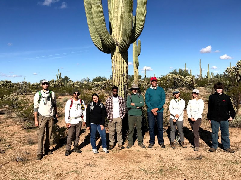 Group photo after the census. Everyone looks happy and behind them is a giant saguaro