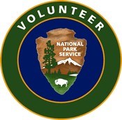 A circular patch with the National Park Service arrowhead centered and a green band with the words volunteer written around it.