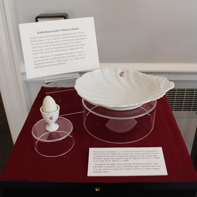 A white egg cup and serving dish with a red C on each.