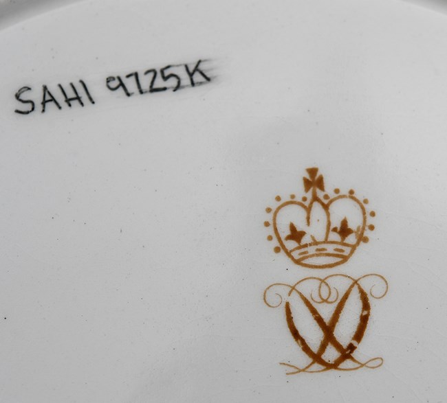 Underside of china plate with Royal Crown Derby Maker's Mark: a crown above a monogram of interlinked D’s