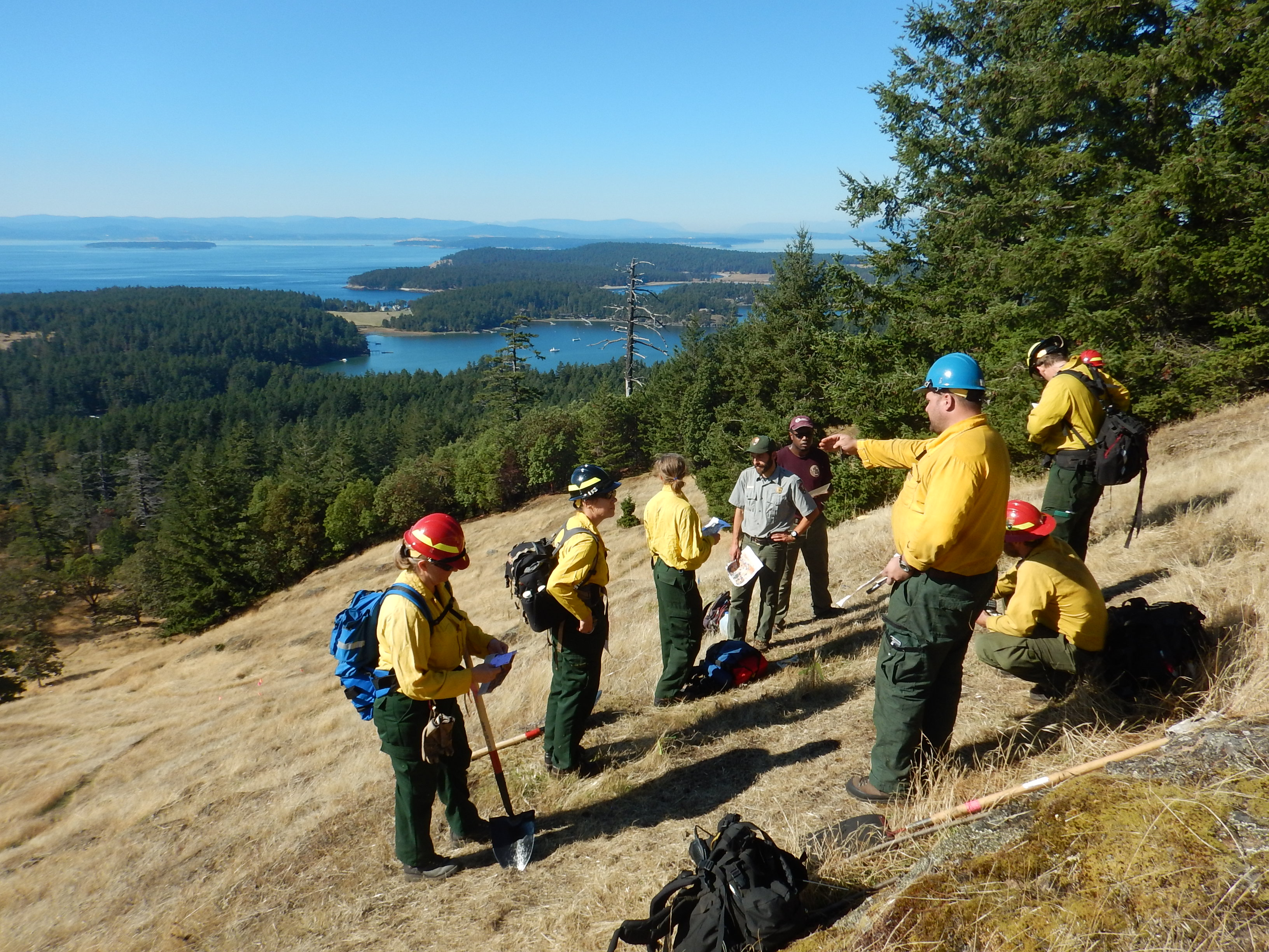 A fire crew and park staff discuss a prescribed burn on Young Hill