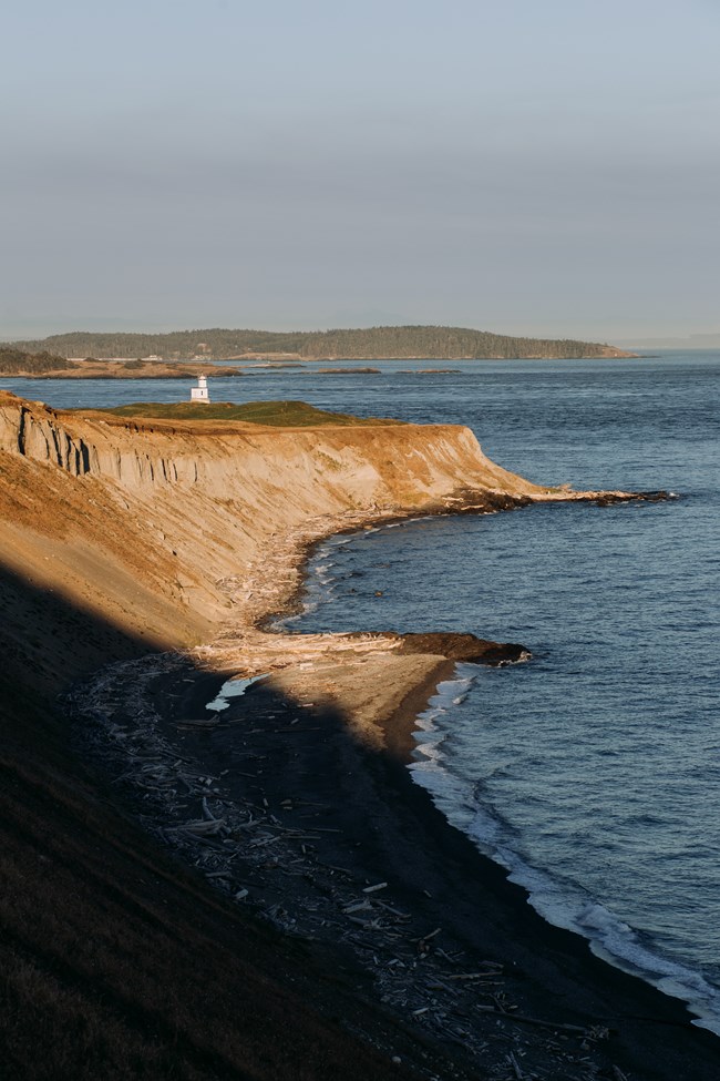 A white lighthouse on an ocean bluff