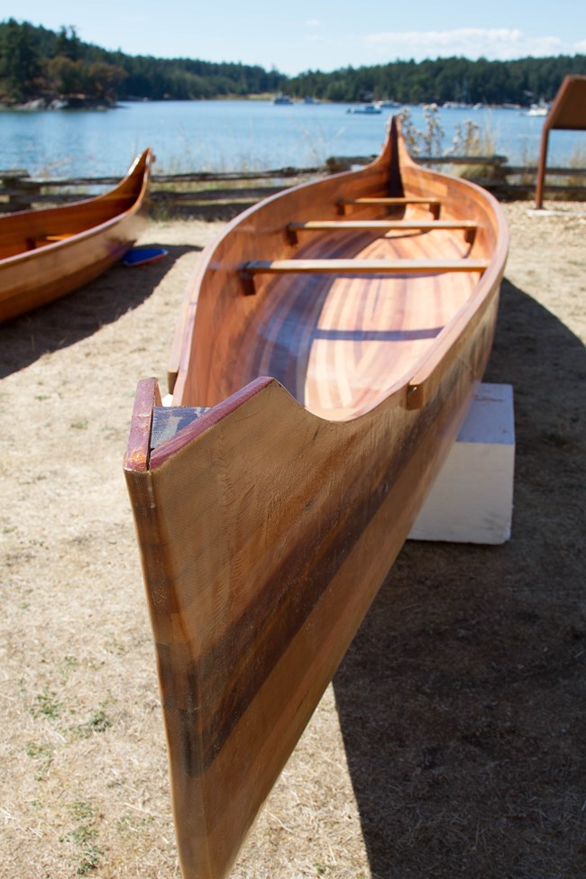 a heavy wooden canoe by the water