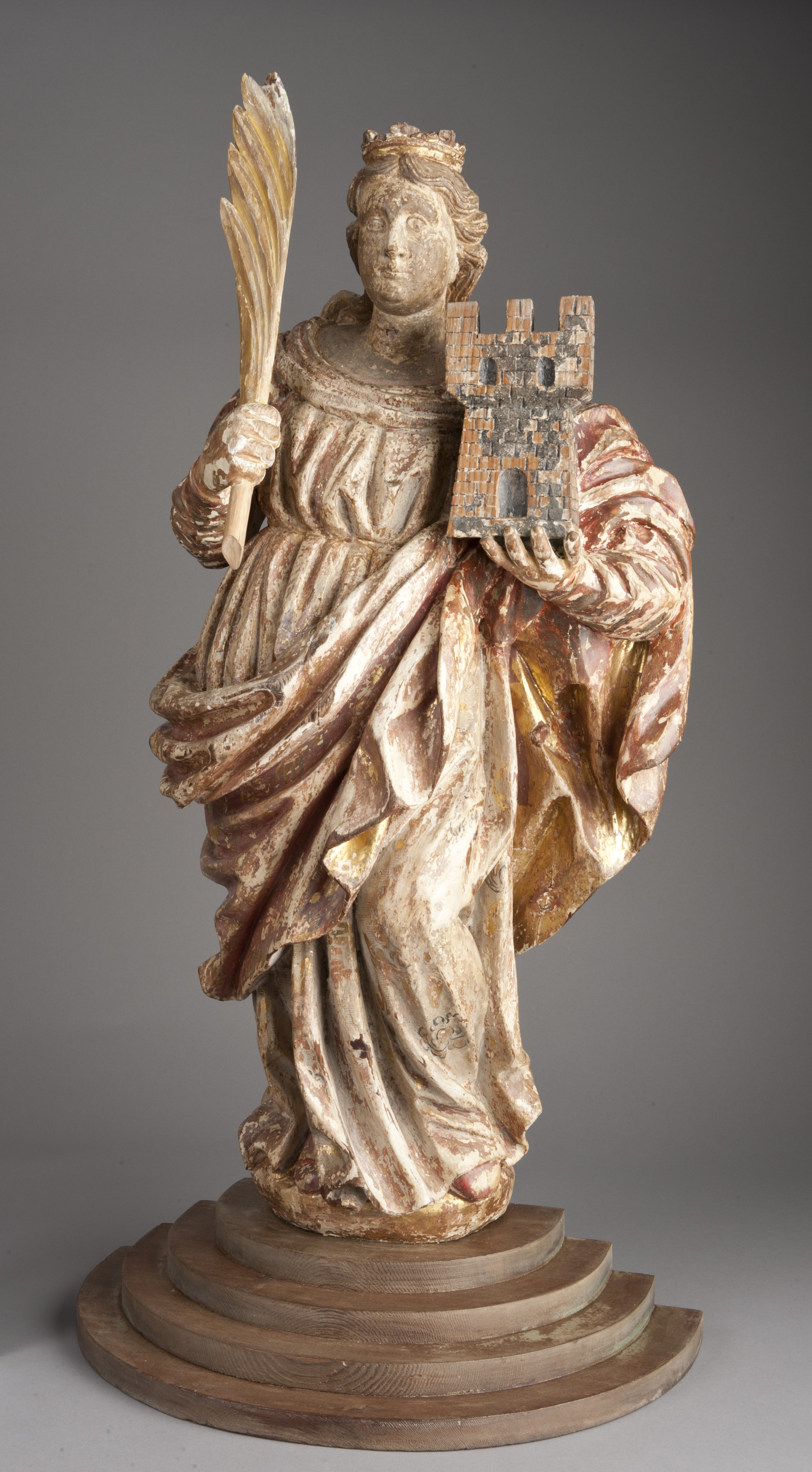 Wooden statue of female saint, St. Barbara, with palm frond and tower