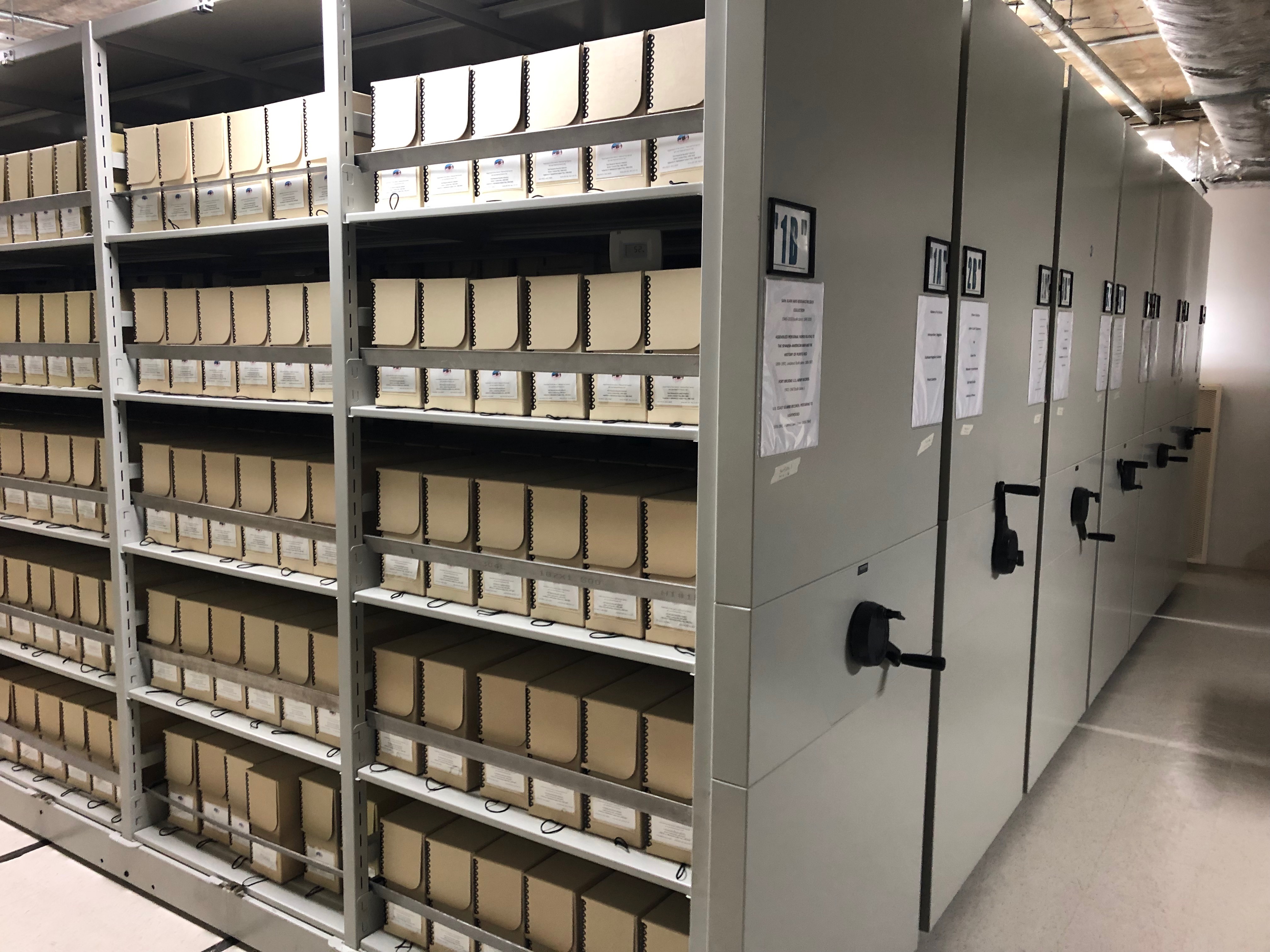 Rolling open shelving with archival boxes on them