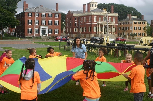 A group play with a large colorful parachute