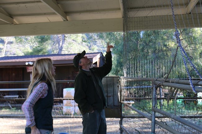 Jeff Sikich pointing at animal enclosure