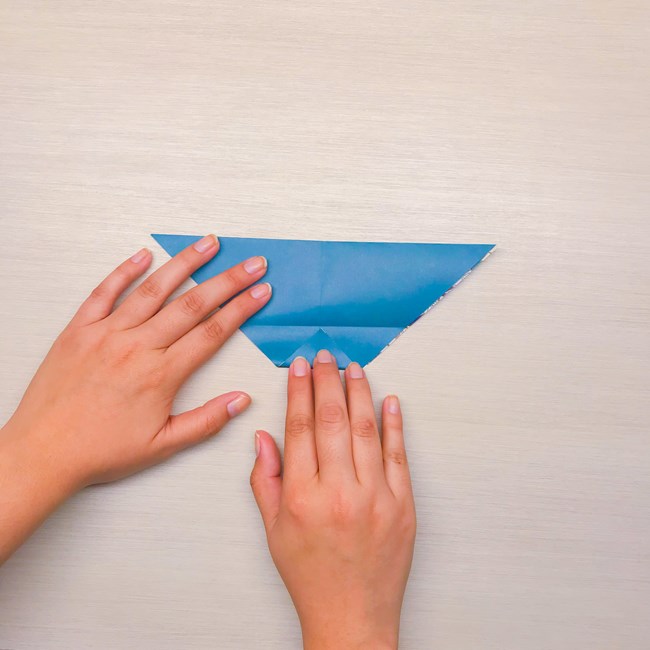 Hands fold a piece of paper.