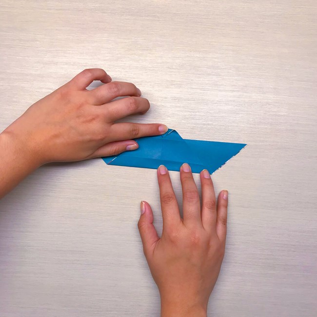 Hands folding the small tip upward.