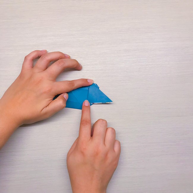 Two index fingers pressing the folds down.