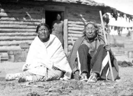 Ellen and Arthur Brady, both survivors of the Sand Creek Massacre at their home on the Northern Cheyenne reservation in Montana. Their daughter Mary stands in the doorway.