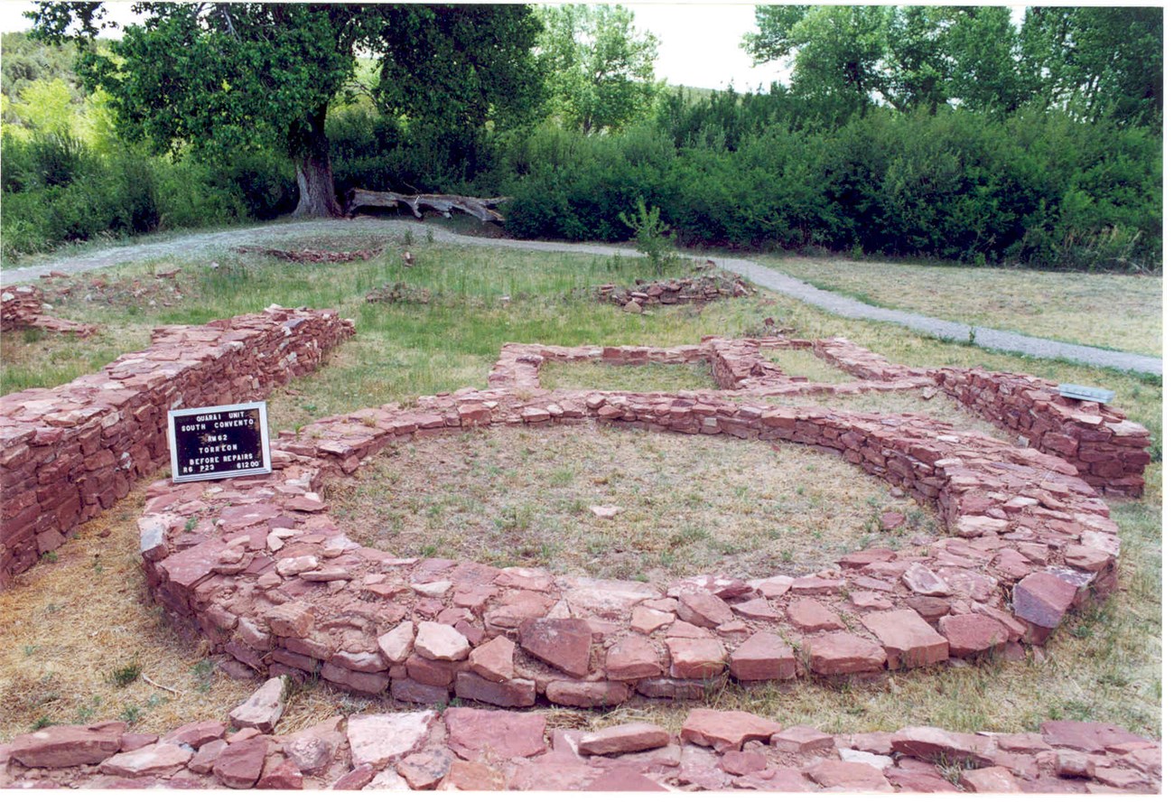 A low circle built of red sandstone is what remains of a torreon at Quarai.