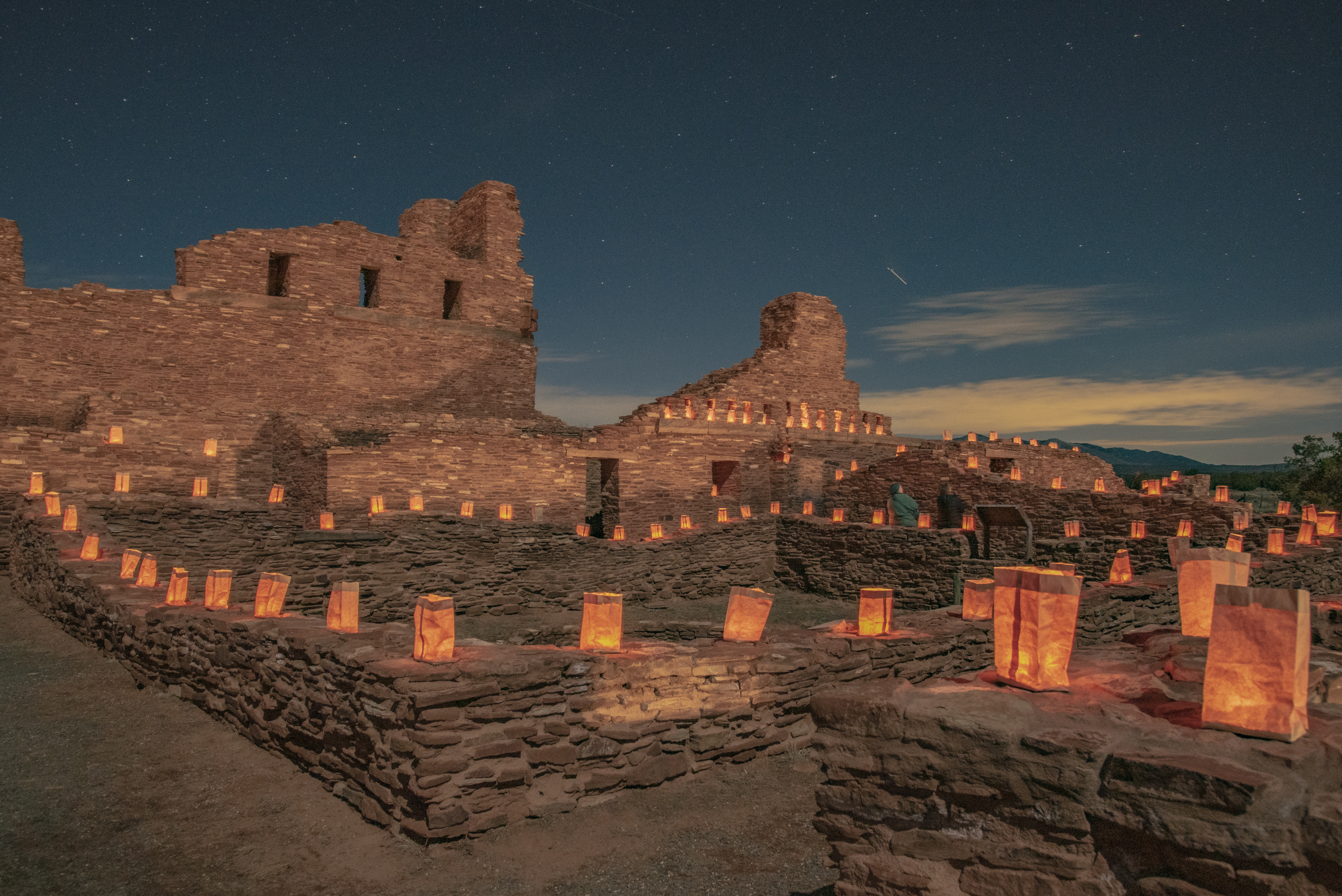 Luminarias resting on top of a rock wall