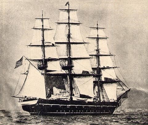 A black and white depiction of a big wooden ship with 15 sails floats on a lake.