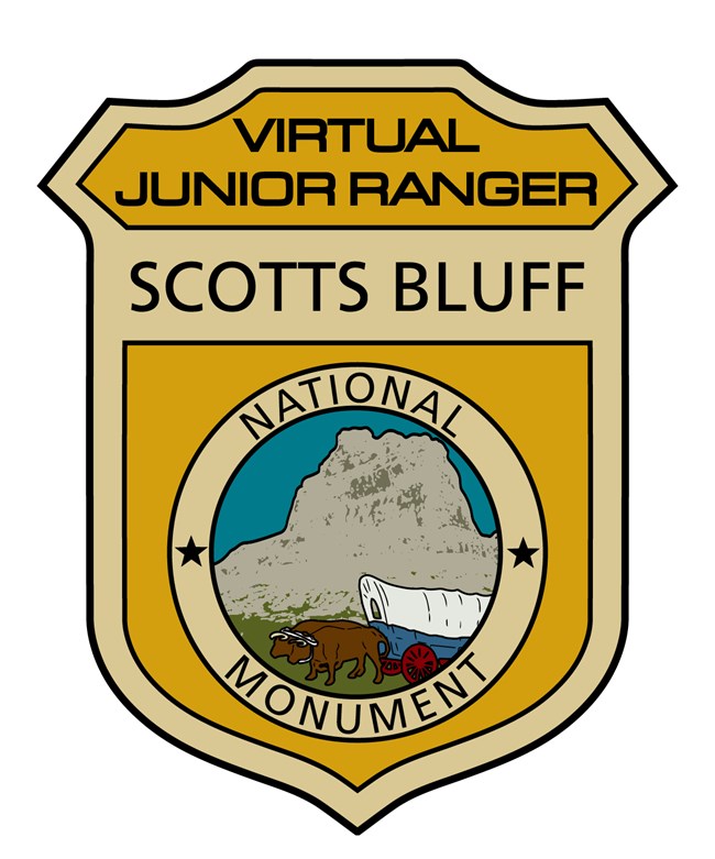 A colorful Virtual Ranger Badge shows oxen pulling a covered wagon in front of a sandstone bluff.