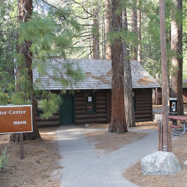 A wooden visitor center in the middle of a forest.