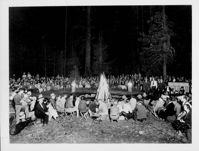 Hundereds of people gather around a campfire for a ranger program in the Giant Forest