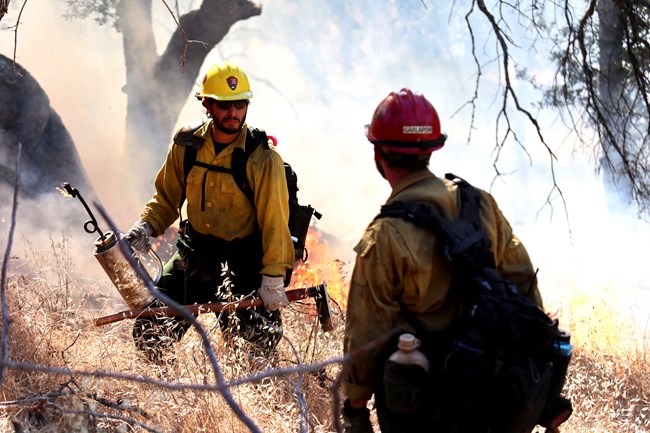 Firefighters communicate with each other during a grassland prescribed burn.