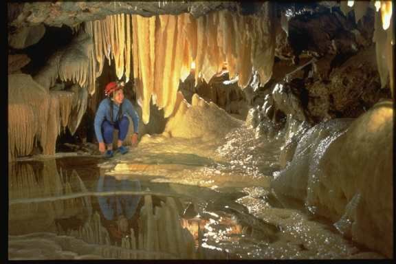 Drapery formation hangs over the Star Chamber pool in Hurricane Crawl Cave