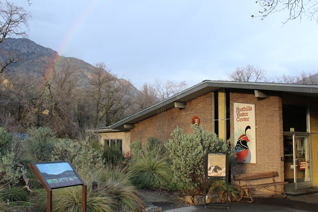 the foothills visitor center with a rainbow in the background