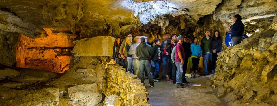People gather in an open room along a cave trail