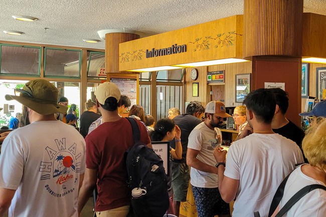 A large crowd of people gathered in a visitor center.