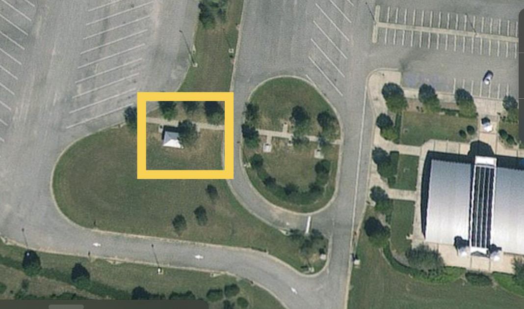 Aerial view of the Lowndes Interpretive Center grounds indicated the First Amendment Area to the west of the building, between the entrance road and the trucking parking lot.