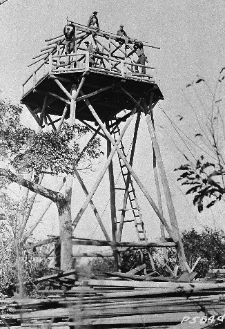 Historic black & white photo of Civilian Conservation enrollees constructing a fire tower.