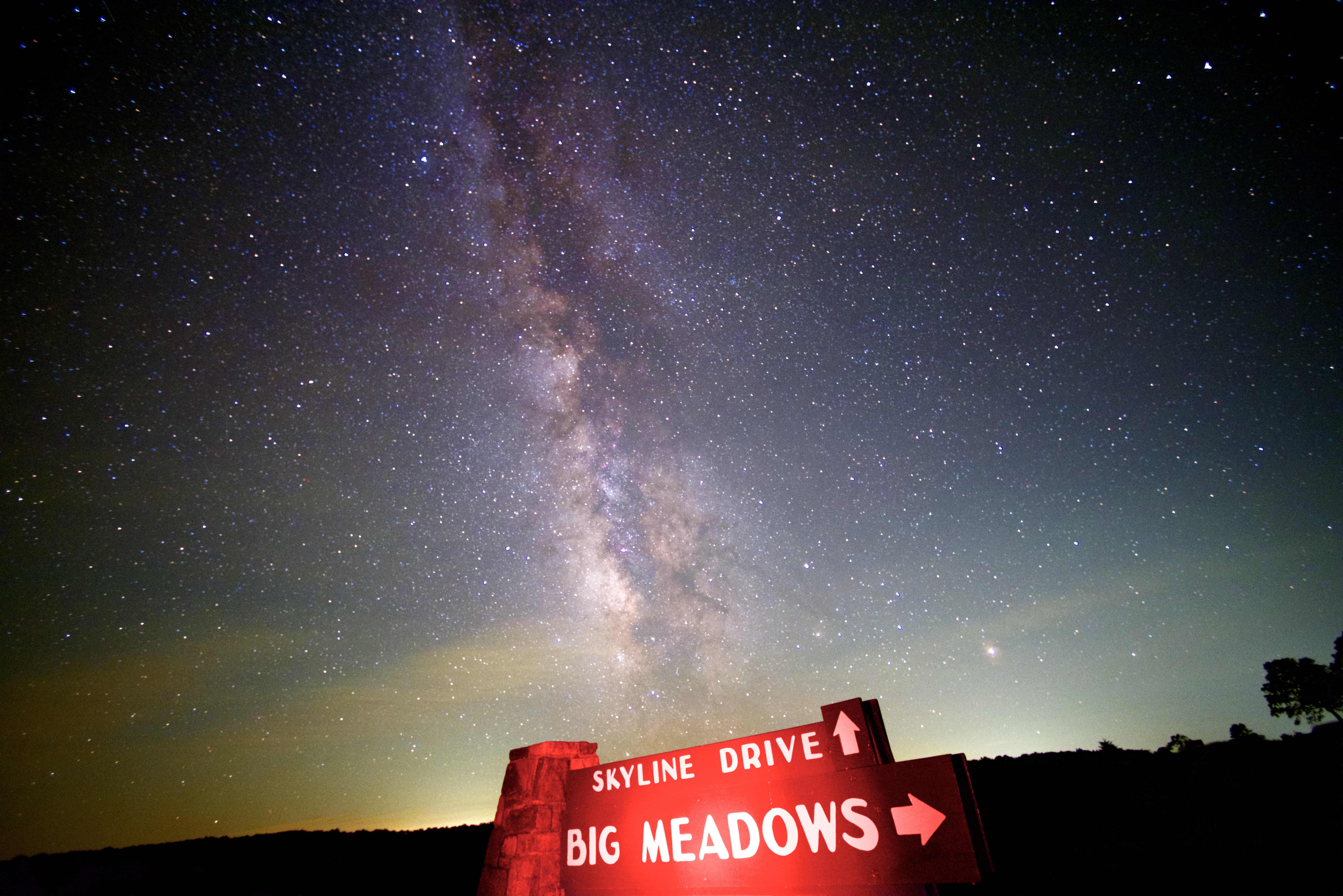 The Milky Way Galaxy cuts across the night sky above the Skyline Drive, Big Meadows sign