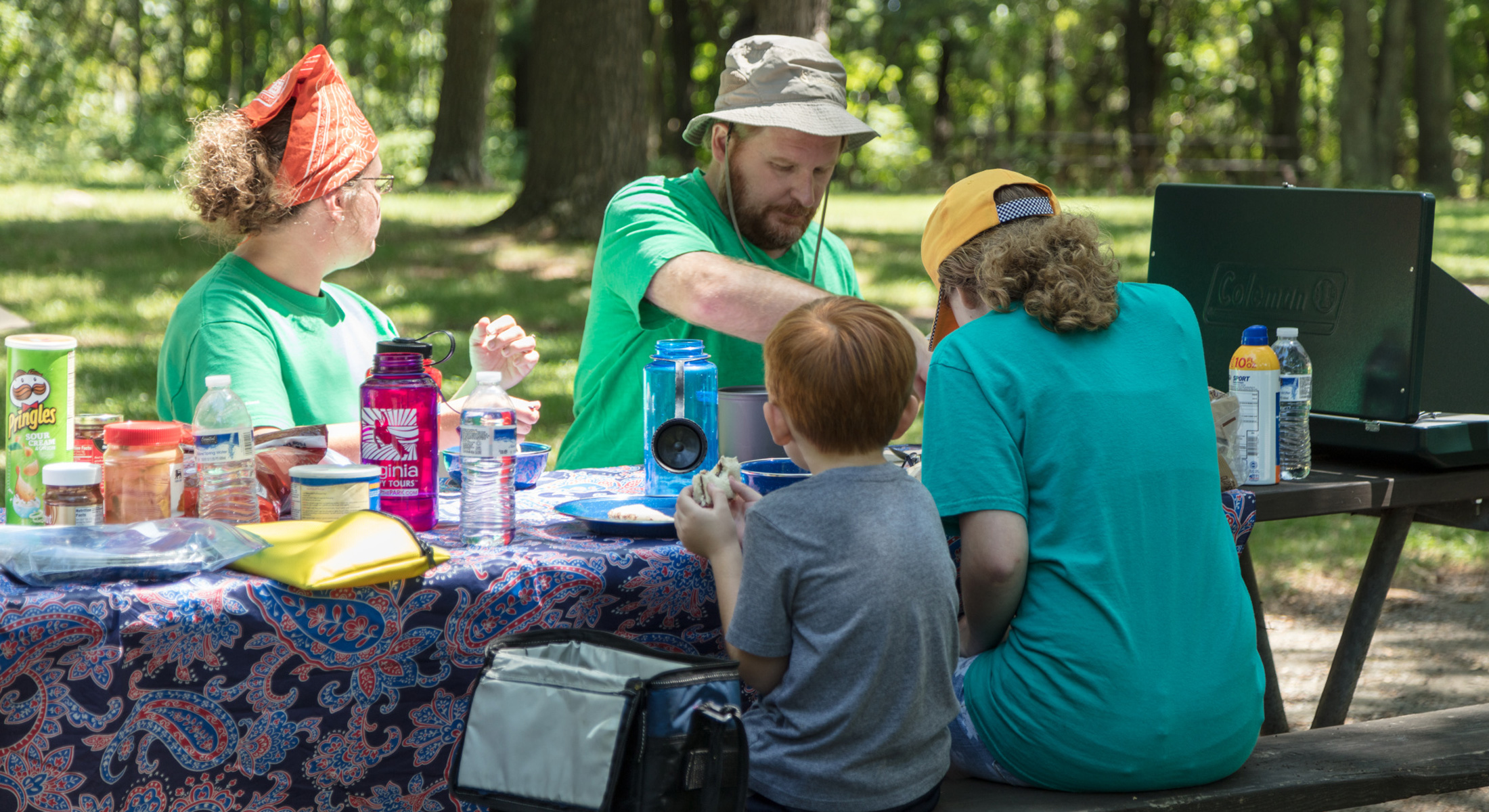 A family sits at a picnic table and eats
