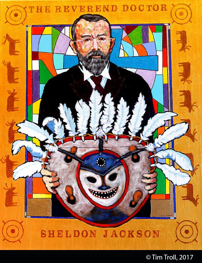 Stylized painting of a man with brown hair and beard, wearing glasses and a suit, holding a large painted and feathered Alaska Native mask. Gold paint frames the image.
