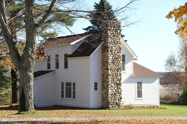 White house with two-story stone chimney