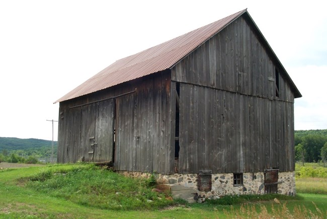 Gray, weathered wood barn on stone foundation