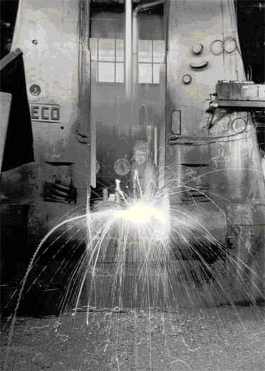 The sparks fly when the hammer hits the hot metal.