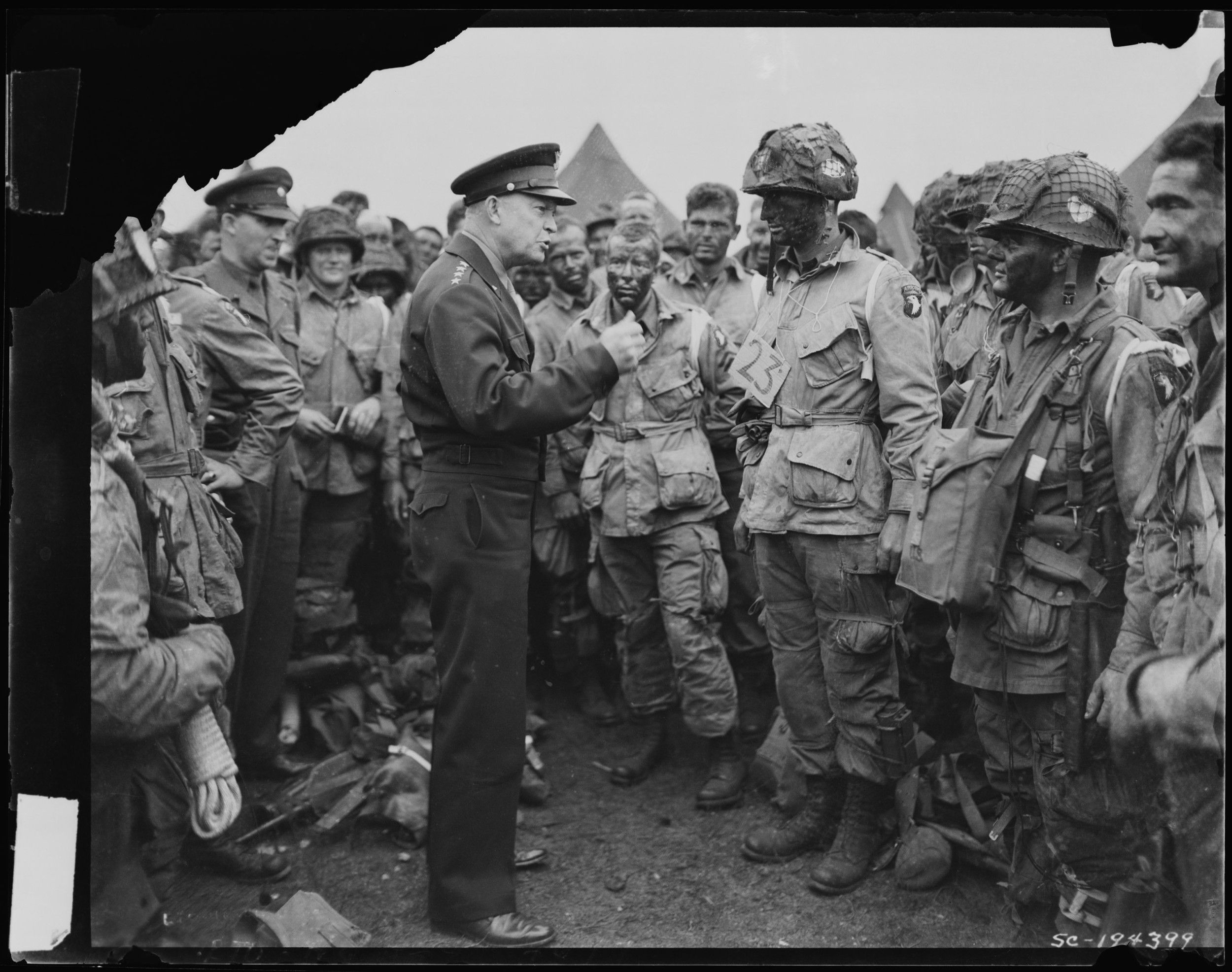 General Eisenhower speaks to a crowd of soldiers.