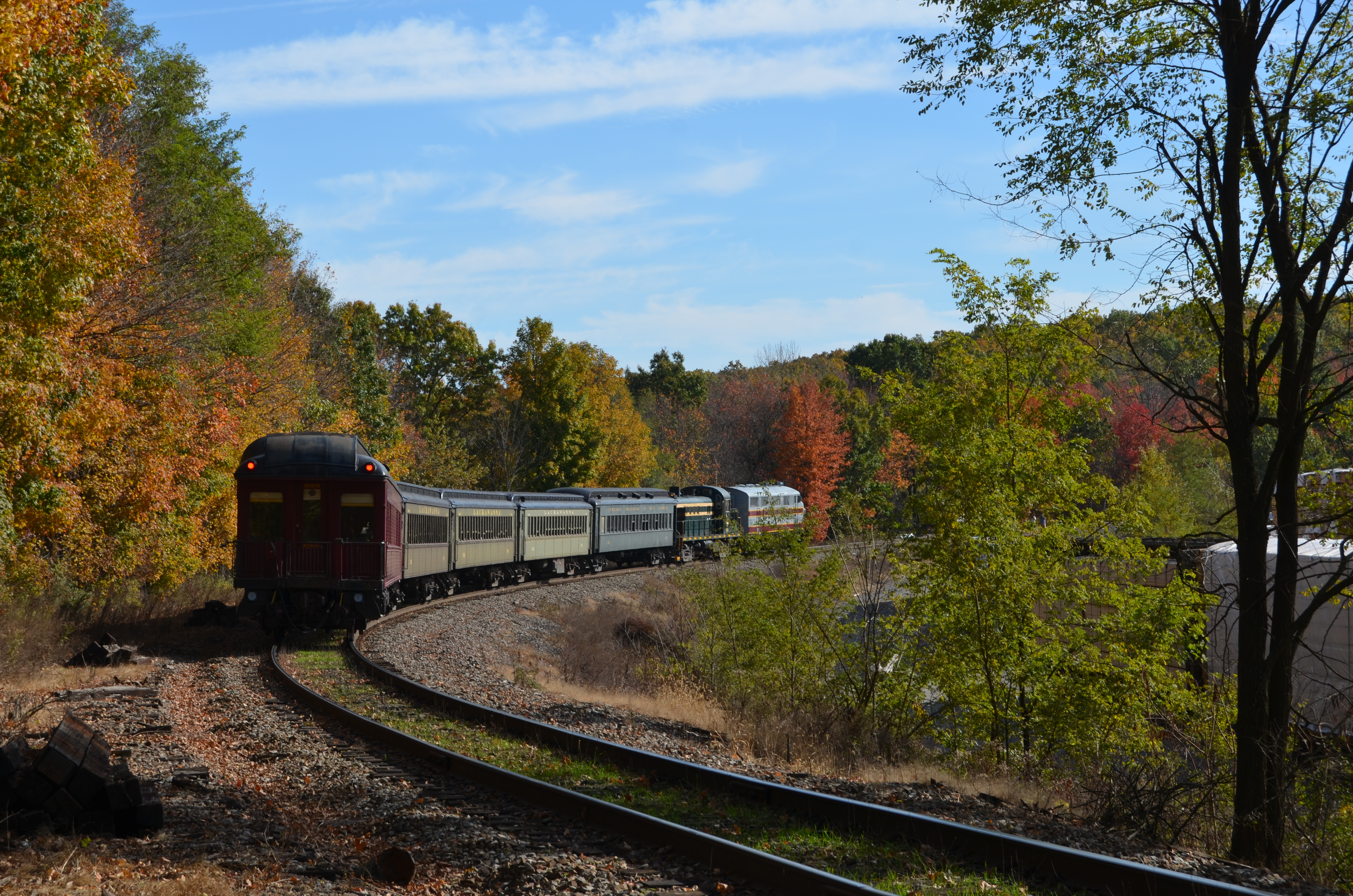 a train moves around a bend surrounded by fall foliage