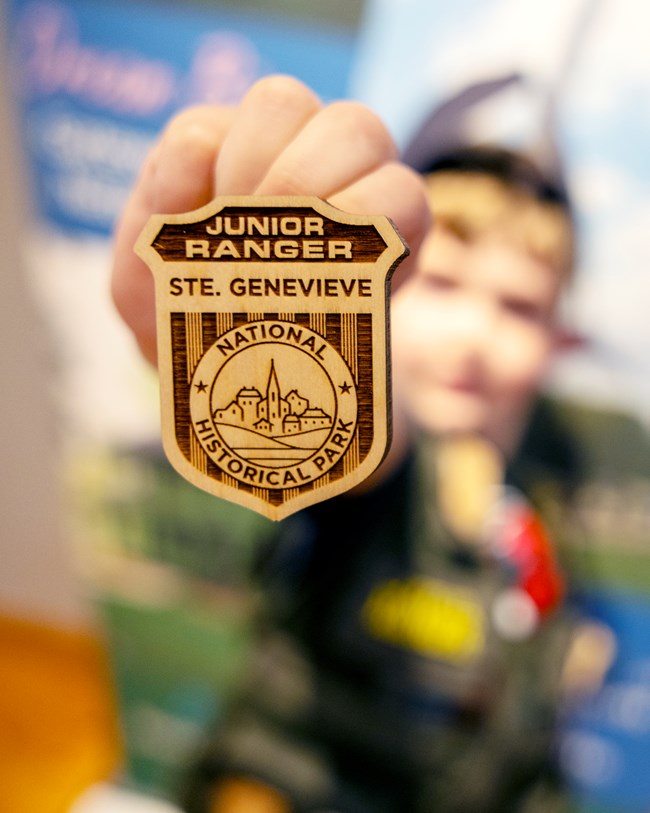 Wooden junior ranger badge with a picture of Ste. Genevieve's skyline