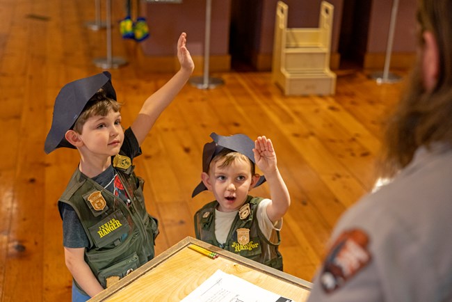 Two boys raise thier hands to take the Junior Ranger pledge