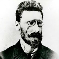 Portrait photo of a man with pince-nez spectacles and a beard.