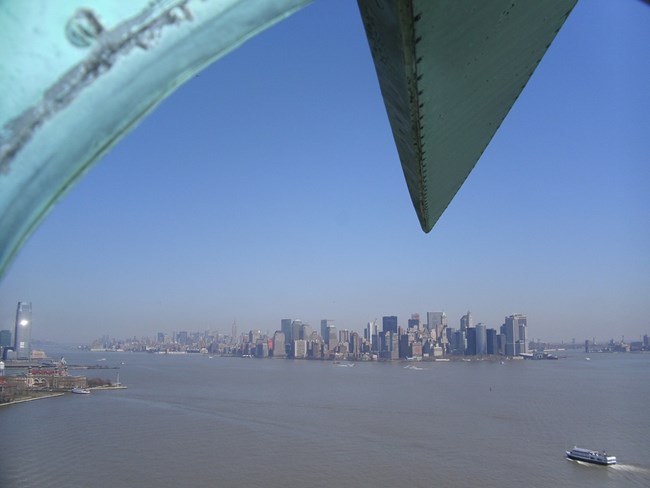 The skyline of New York City as seen from the small windows inside the Statue of Liberty's Crown.
