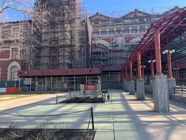 The exterior of Ellis Island shows a covered awning and three-story building.