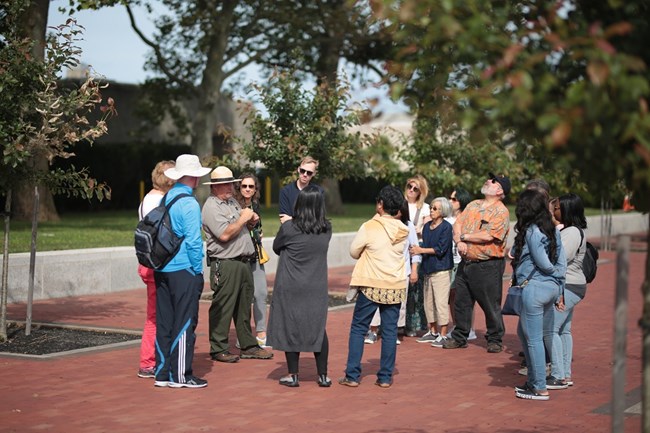 A park ranger gives an interpretive tour on Liberty Island to a group of visitors.