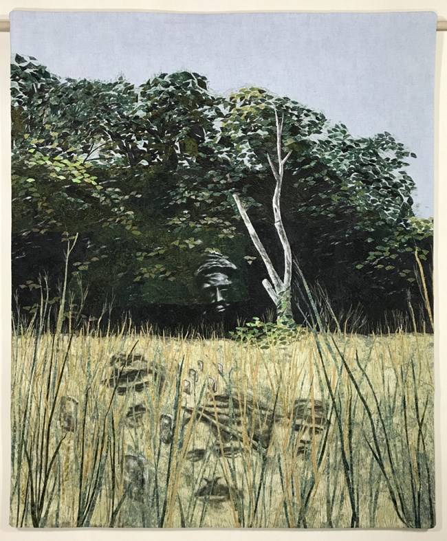 Ghostly images of soldiers imposed on a grassy landscape with trees in the background.