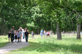 A park ranger leads a group of students on a hike.