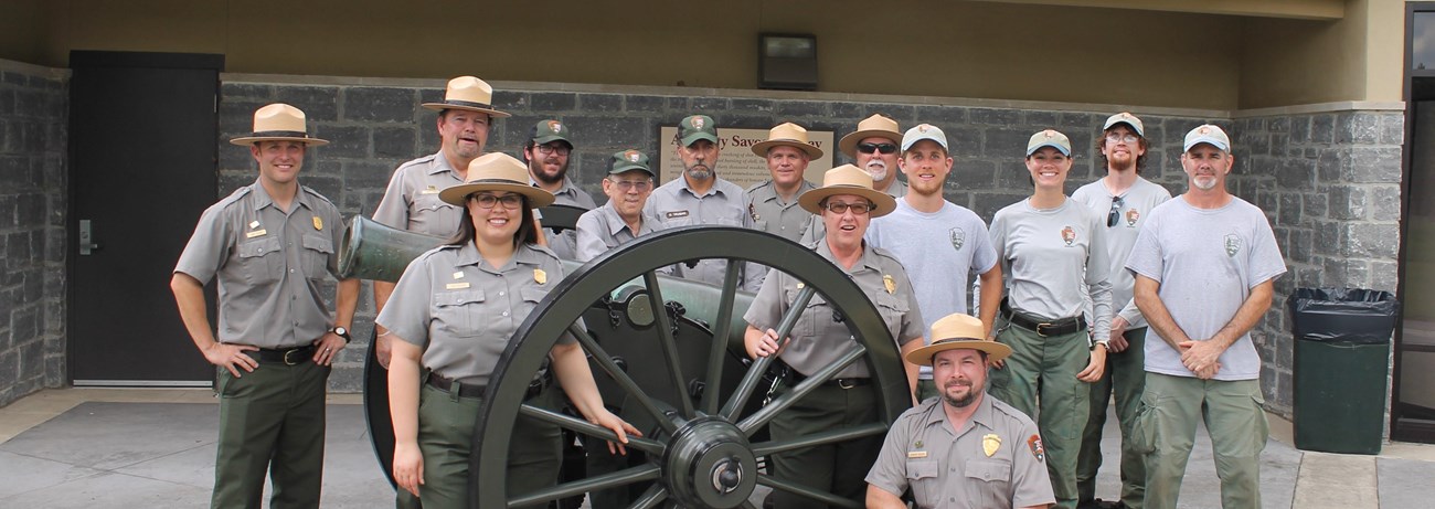 Park Rangers stand around a cannon