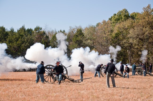 Clouds of smoke come from two Civil War cannons.