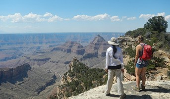 Two visitors look down on the Colorado river from the north rim of the Grand Canyon