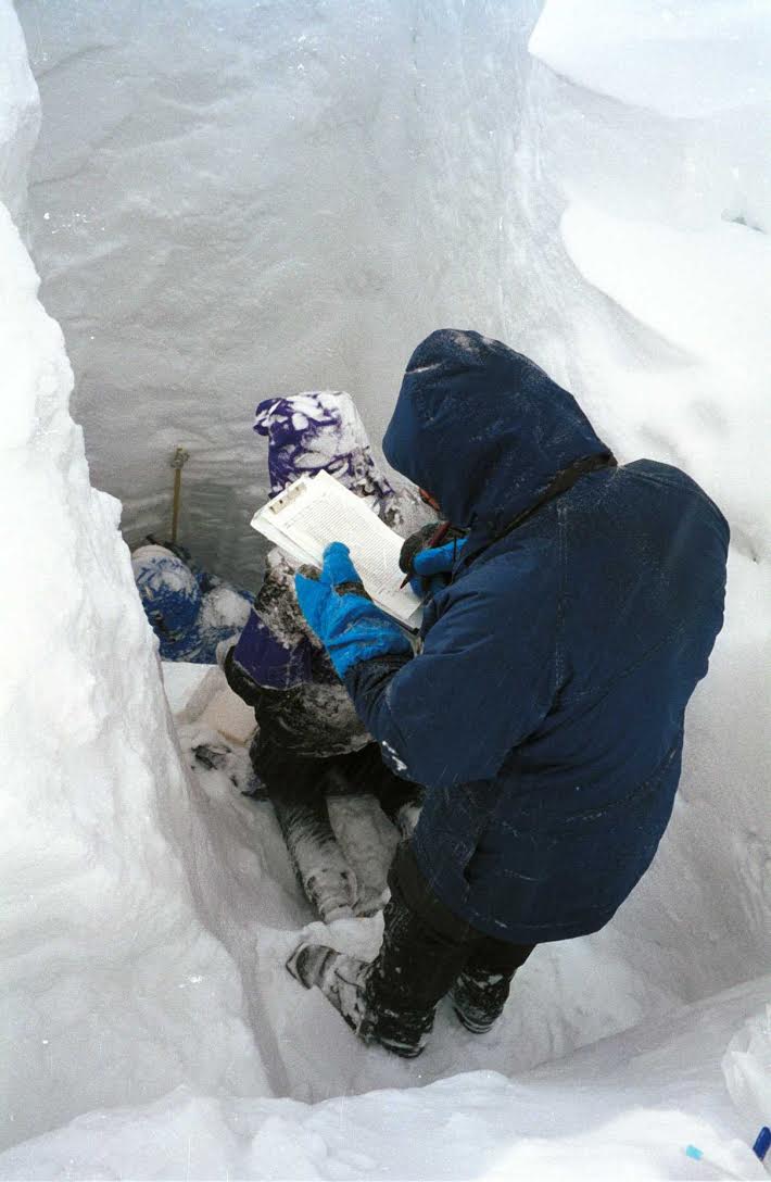 People recording measurements in a snowpack