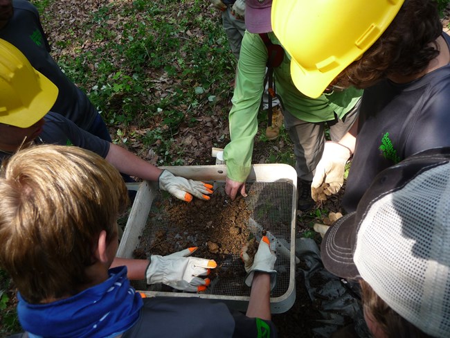 Youth are supervised while excavating