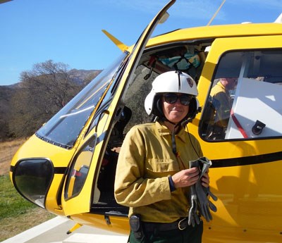 Woman pilot standing outside her helicopter